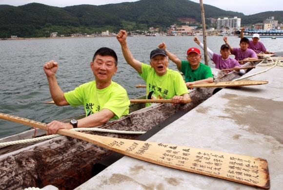 6일 경남 거제시 지세포항에서 일본인들이 고대 뱃길을 고증하기 위해 만든 통나무배를 타고 대한해협을 건너 대마도로 항해하기 전 파이팅을 외치고 있다. 거제 연합뉴스