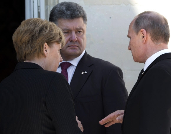 페트로 포로셴코(왼쪽에서 두 번째) 우크라이나 대통령 당선자가 6일 프랑스 노르망디 상륙작전 70주년 기념식 오찬장에 들어가기 전 앙겔라 메르켈(왼쪽) 독일 총리, 블라디미르 푸틴(오른쪽) 러시아 대통령과 짧은 대화를 나누고 있다. 포로셴코가 당선 뒤 푸틴을 만난 것은 이날이 처음이다. 노르망디 AP 연합뉴스