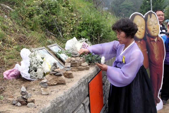 13일 오전 경기도 양주시 광적면 효촌리 56번 지방도로에서 열린 ’고 신효순 심미선 12주기 추모행사’에서 박상희 목사가 영정사진 앞에 국화꽃을 헌화하고 있다.  양주 연합뉴스