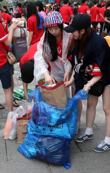 18일 브라질월드컵 한국 대 러시아의 경기를 응원하기 위해 서울 광화문광장에 모인 시민이 거리 응원을 마친 후 주변을 정리하고 있다.  연합뉴스