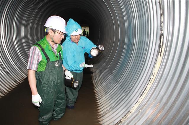 소나기가 거세게 내린 23일 이동진(왼쪽) 도봉구청장이 중랑천변 하수암거 내부를 점검하고 있다. 도봉구 제공