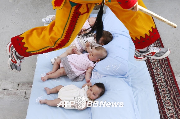 스페인의 카스드릴로 드 무르시아라는 도시에서 ‘엘 콜라초(아기 뛰어넘기 축제)’ 기간 중인 22일(현지시간) 악령으로 분장한 한 남자가 매트리스에 누워있는 아기들을 뛰어넘고 있다. 사진ⓒAFPBBNews=News1/ 온라인뉴스부 iseoul@seoul.co.kr