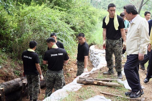 노현송(오른쪽) 강서구청장이 최근 한 야산의 공사 현장을 찾아 작업을 돕는 군인들을 격려하고 있다. 강서구 제공