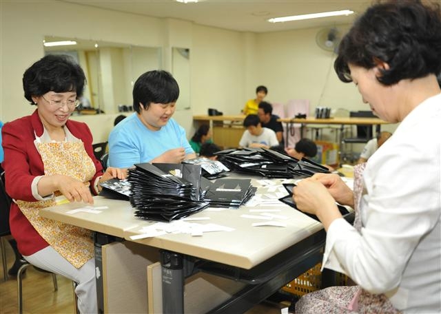 1일 거여동 임마누엘복지재단에서 박춘희(왼쪽) 구청장이 쇼핑백을 접는 봉사활동을 하고 있다. 송파구 제공