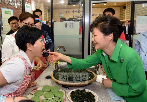 11일 박근혜대통령이 김포 로컬푸드 공동판매장에서 체험관을 참관하며 쑥개떡만들기 체험말을 듣고 매장직원에게 쑥개떡을 먹여주고 있다.  이언탁 기자 utl@seoul.co.kr