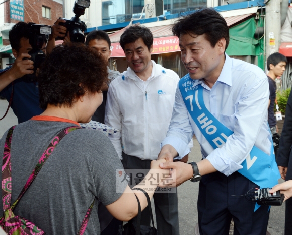 기동민(오른쪽) 새정치민주연합 후보가 13일 동작구 사당동 남성시장에서 한 시민의 손을 잡고 지지를 호소하고 있다.  안주영 기자 jya@seoul.co.kr