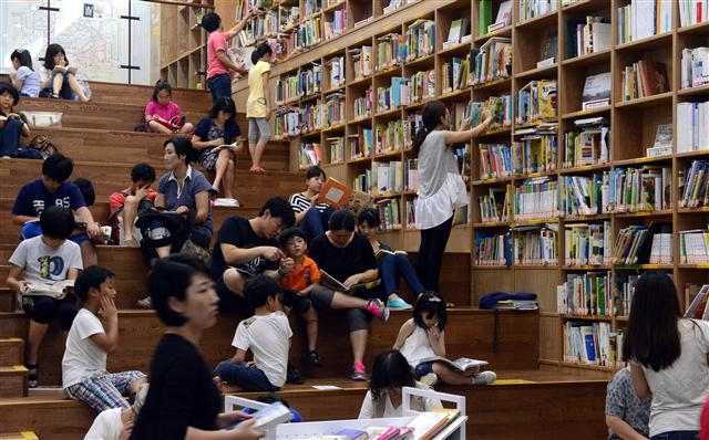 여름방학을 맞은 초등학생과 그 가족들이 서울도서관에서 자유롭게 책을 읽고 서가에서 책을 고르는 모습. 전문가들은 초등학생에게 여름방학은 독서나 생활 습관을 고치기에 딱 좋은 기간이라고 말한다. 서울신문 포토라이브러리