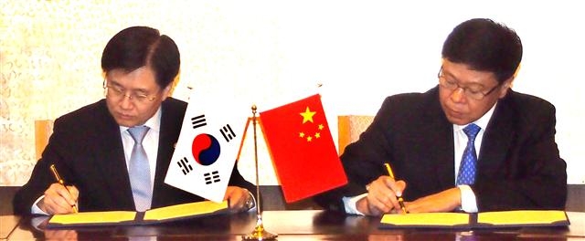 김덕중(왼쪽) 국세청장이 14일 중국 베이징에서 열린 한·중 국세청장회의에서 이전가격 사전합의문에 서명하고 있다. 국세청 제공