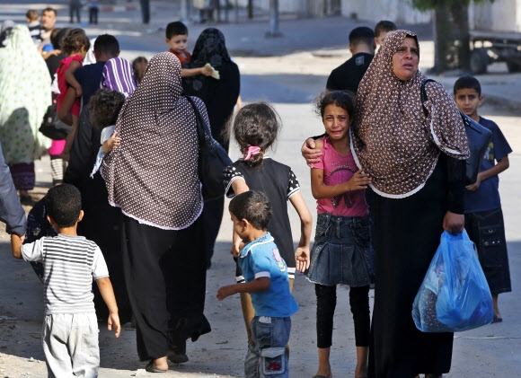 팔레스타인 가자지구 북부 가자시티에서 16일 마을 주민들이 피란을 떠나는 가운데 한 소녀가 엄마 옆에서 울음을 터뜨리고 있다. 가자시티 AP 연합뉴스