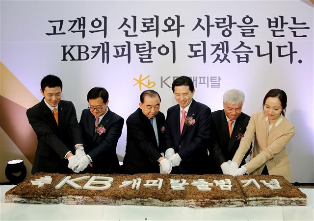 지난 3월 KB금융그룹의 열한 번째 계열사로 들어온 KB캐피탈의 공식 출범식에서 임영록(오른쪽에서 세 번째) KB금융 회장이 떡케이크를 자르고 있다. KB금융 제공