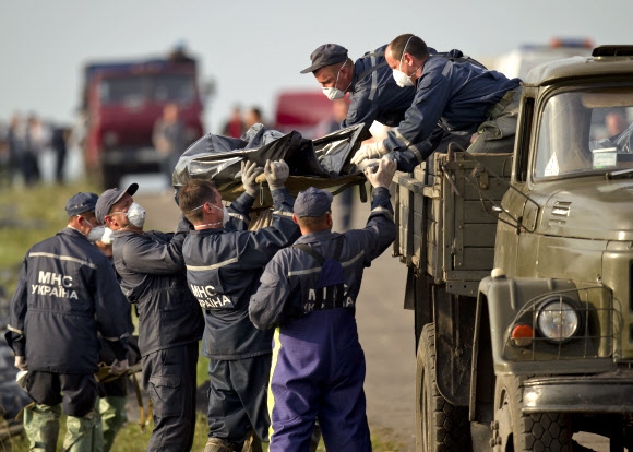 19일(현지시간) 우크라이나 동부 도네츠크주 그라보베 인근에서 구조요원들이 말레이시아항공 소속 MH17편의 희생자 시신을 트럭에 옮겨 싣고 있다. 시신이 갈가리 찢겨 있어 하나하나 일일이 찾아서 맞춘 뒤 이동시키고 있다. 그라보베 AP 연합뉴스