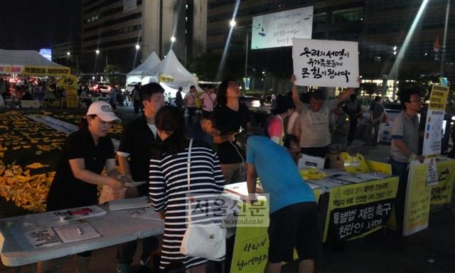 지난 19일 서울 종로구 광화문광장에서 시민들이 ‘세월호특별법’ 제정 촉구를 위한 서명운동에 동참하고 있다. 일부는 광장 잔디 위에 노란색 종이로 접은 돛단배를 올려놓는가 하면 단식 농성을 하고 있는 희생자 가족들에게 위로의 말을 건네기도 했다.