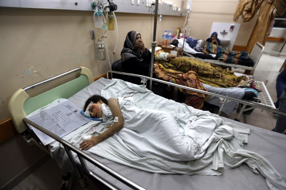 이스라엘의 포격에 부상을 당한 일곱 살 소녀 베이산 다히르가 20일(현지시간) 가자지구 가자시티의 시파병원 병상에서 치료를 받은 뒤 잠들어 있다. 그는 이날 공격으로 집이 무너져 부모와 오빠, 언니, 여동생을 모두 잃었다. 가자시티 AP 연합뉴스