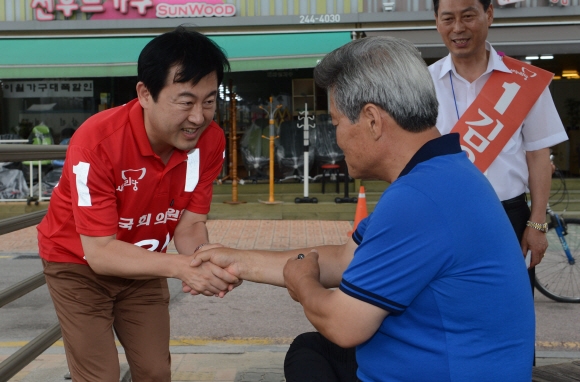 7·30 재·보궐선거에 출마한 수원병 김용남(왼쪽) 새누리당 후보가 22일 경기 수원시 팔달문 시장에서 상인과 악수를 나누며 지지를 호소하고 있다. 
