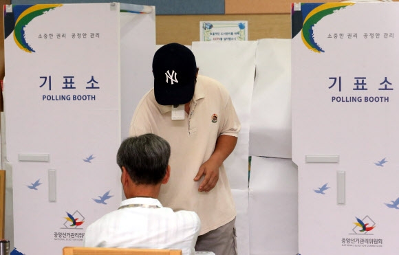 7·30 국회의원 재·보궐선거 사전투표가 실시된 25일 서울 동작구 흑석동 주민센터에 차려진 사전투표소에서 유권자들이 투표하고 있다.  연합뉴스