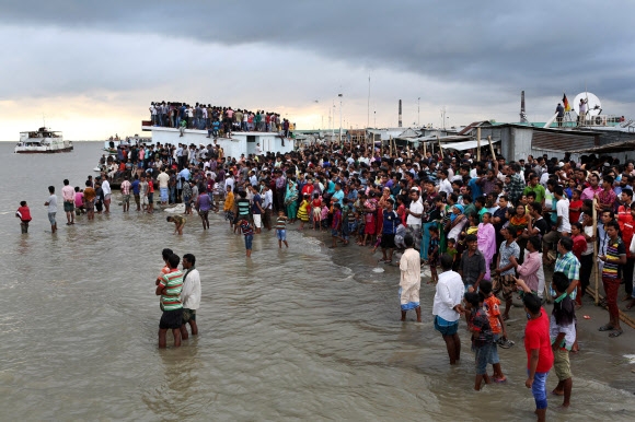4일(현지시간) 방글라데시 수도 다카 인근 파드마 강에서 여객선이 침몰하는 사고가 발생하자 탈출한 사람을 구조하고 부상자를 보살피기 위해 인근 마을 주민들이 강둑에 나와 있다. 다카 AP 연합뉴스