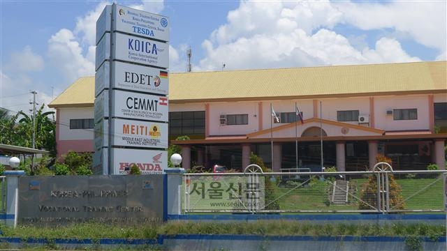 ‘한·필리핀 직업훈련학교’ 앞에 펄럭이는 태극기와 함께 한국국제협력단(코이카) 등 주요 지원기관들의 이름을 표시한 표지판이 서 있다.