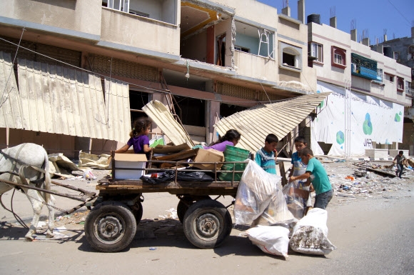 10일(현지시간) 팔레스타인 가자지구의 가자시티에서 어린이들이 잔해 더미에서 쓸만한 물건을 주워담고 있다.  연합뉴스