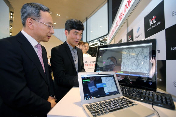 황창규(왼쪽) KT 회장이 승현준 교수와 12일 서울 광화문 올레스퀘어에서 뇌의 신경세포 지도를 그리는 온라인 게임 ‘아이와이어’를 시연해 보이고 있다. KT 제공
