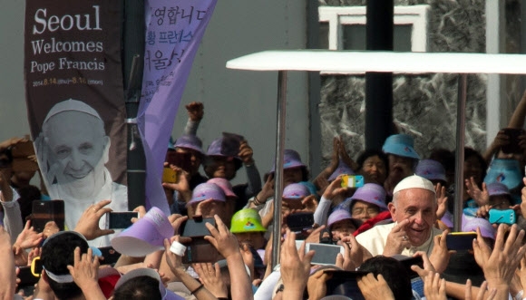 16일 프란치스코 교황이 시복식 미사가 열리는 광화문 광장 주변을 차량으로 돌며 인사하고 있다. 연합뉴스