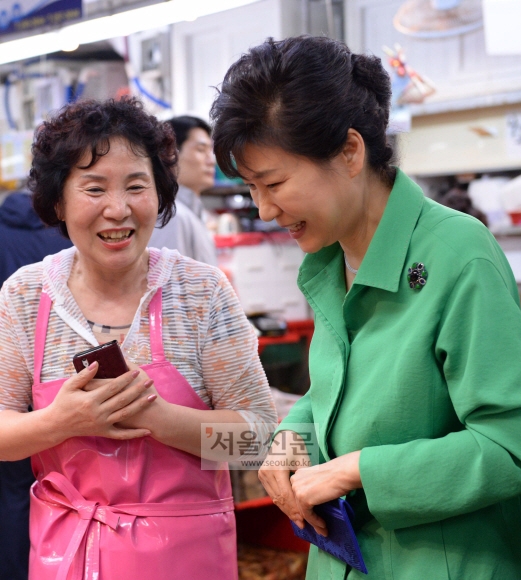 박근혜 대통령이 22일 부산 남포동 자갈치시장을 방문, 상인과 이야기를 나누며 수산물을 고르고 있다. 청와대사진기자단
