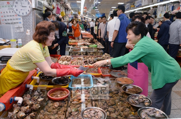 박근혜 대통령이 22일 오후 부산 남포동 자갈치시장을 찾아 상인들과 얘기를 나눈 후 해산물을 구입하고 있다.  청와대사진기자단
