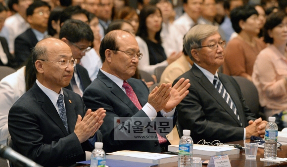 문형표(왼쪽) 보건복지부 장관이 김종대(가운데) 국민건강보험공단 이사장, 신영수(오른쪽) 세계보건기구(WHO) 서태평양지역 사무처장과 함께 22일 서울 중구 한국프레스센터에서 건보공단 주최로 열린 ‘담배 규제와 법’ 국제 심포지엄에 참석해 국내외 전문가의 발표를 들은 뒤 박수를 치고 있다.  이언탁 기자 utl@seoul.co.kr