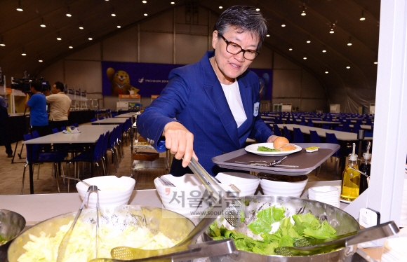 이에리사 촌장이 선수촌 식당에서 시식을 위해 음식을 담고 있다.  안주영 기자 jya@seoul.co.kr