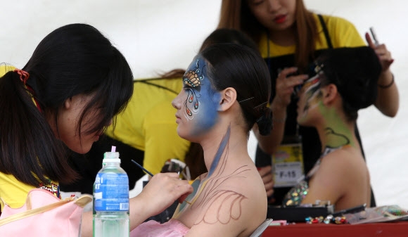 31일 오후 대구 달서구 두류공원에서 열린 ’2014 대구국제보디페인팅 페스티벌’에서 참가자들이 모델 얼굴에 보디페인팅 작업을 하고 있다.  연합뉴스
