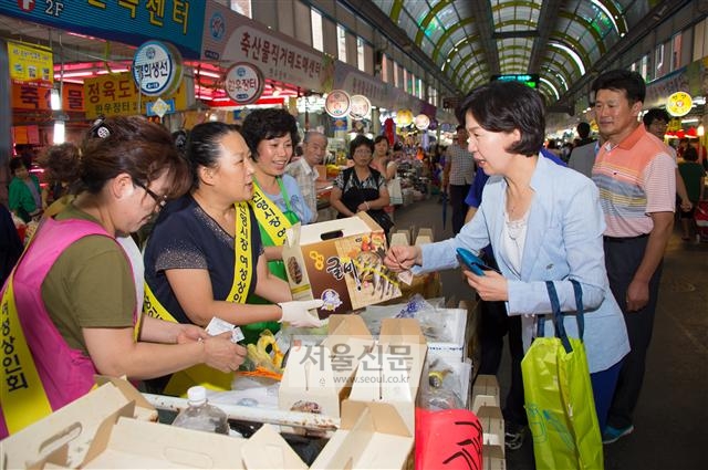추석 연휴를 앞둔 2일 신월동 신영시장에서 김수영 양천구청장이 물건을 사며 상인들과 이야기하고 있다.