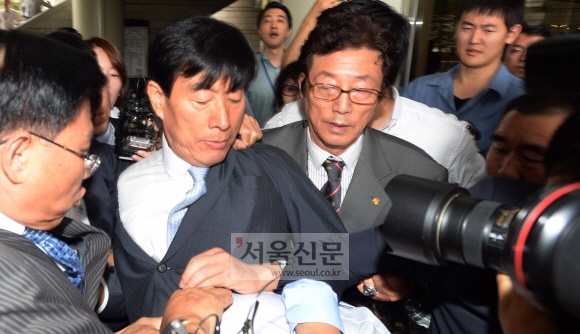 18대 대통령 선거에 개입한 혐의로 기소된 원세훈(왼쪽에서 두 번째) 전 국가정보원장이 11일 서울중앙지법에서 열린 1심에서 집행유예 선고를 받고 법원을 빠져나가려다 기다리고 있던 취재진에게 둘러싸여 있다. 손형준 기자 boltagoo@seoul.co.kr
