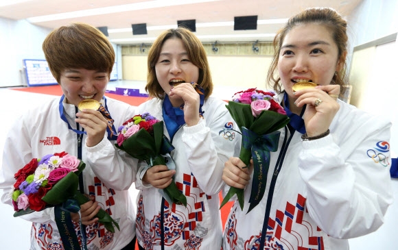 22일 인천 옥련국제사격장에서 열린 2014 인천 아시안게임 사격 여자 25m 권총 단체전에서 금메달을 획득한 한국여자 사격대표팀이 사진촬영을 하고 있다. 왼쪽부터 김장미, 이정은, 곽정혜.  연합뉴스