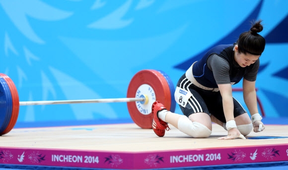 22일 달빛축제정원 역도경기장에서 열린 2014 인천 아시안게임 역도 여자 58kg급 경기에서 한국 서정미가 용상 3차시기에서 110kg에 도전하다 실패한 후 아쉬워하고 있다.  연합뉴스