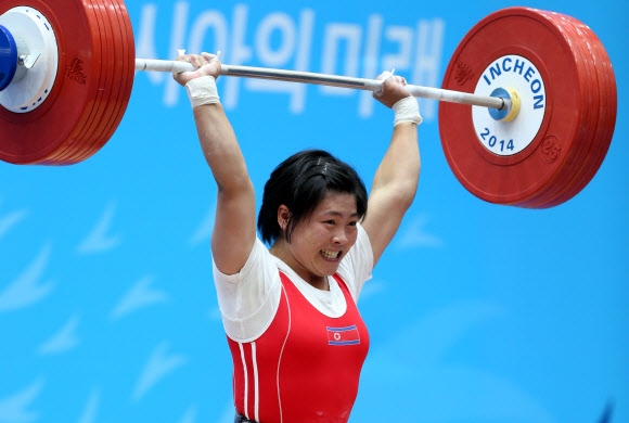 22일 달빛축제정원 역도경기장에서 열린 2014 인천 아시안게임 역도 여자 58kg급 경기에서 북한의 리정화가 용상 2차 시기에서 134kg을 들어올리고 있다. 리정화는 인상 102kg, 용상 134kg 합계 236kg으로 2위 중국의 왕 솨이를 1kg 앞서며 금메달을 획득했다.  연합뉴스