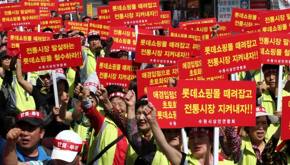 23일 오전 경기도 수원시 팔달구 수원역광장에서 수원지역 22개 전통시장 상인들로 구성된 수원시상인연합회 회원들이 개점이 임박한 롯데몰수원점 철수를 요구하는 집회를 개최하고 있다.  연합뉴스