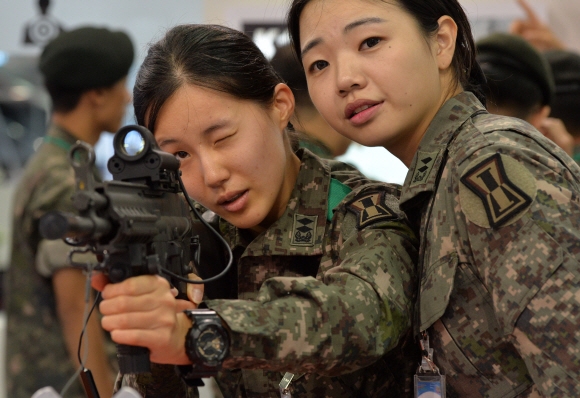 24일 경기도 일산 킨텍스에서 개최된 대한민국 방위산업전(DX Korea 2014)에서 여군들이 국내 방산업체인 S&T모티브가 개발한 K2C 소총을 살펴보고 있다. 손형준기자 boltagoo@seoul.co.kr