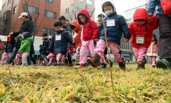 어린이집 원생들이 ‘시민과 함께하는 보리밟기 행사’에서 보리 새싹을 밟고 있다.