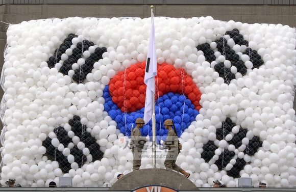 28일 제64주년 서울수복 기념행사에서 해병대병사들이 태극기를 게양하고 있다.