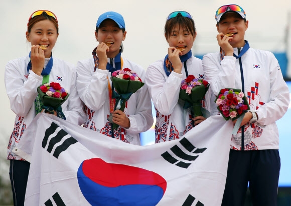 최민지(왼쪽부터), 양수진, 김선우, 정미나가 근대5종 여자 단체전에서 대회 첫 정상에 오른 뒤 시상식에서 금메달을 깨물고 있다. 연합뉴스