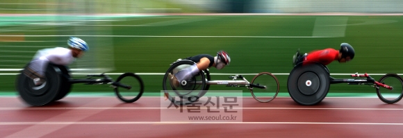 바퀴가 셋 달린 휠체어로 트랙을 질주하는 육상은 장애인경기대회의 인기 종목이다.