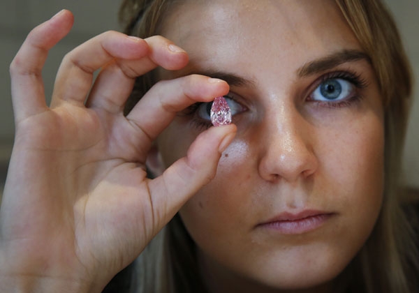 한 여성이 7일(현지시간) 홍콩에서 열린 경매에서 1770만 달러에 팔린 8.41캐럿짜리 ‘팬시 비비드급’(색이 있는 다이아몬드 중 최고 등급)인 핑크 다이아몬드를 들고 있다.  AP/뉴시스
