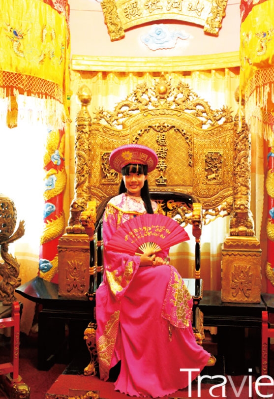 바오 다이 별장에서 왕족의 옷을 입고 기념사진을 찍는 소녀