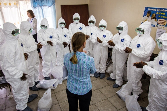 9월 19일(현지시간) 시에라리온 수도 프리타운에서 세계보건기구(WHO) 직원(가운데)이 간호사들에게 에볼라 방호장비 사용법을 가르치고 있는 모습 AP/뉴시스