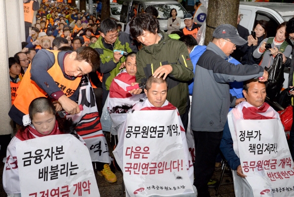 전국공무원노조(위원장 이충재) 조합원 200여명이 20일 서울 세종로 정부종합청사 앞에서 정부와 새누리당이 추진하고 있는 공무원연금 개정안을 반대하는 집회를 열고 지도부가 삭발을 하고 있다  이호정 기자 hojeong@seoul.co.kr