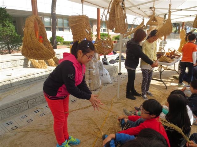 27일 ‘친환경 체험교육’ 행사장에서 어린이들이 볏짚 공예품을 만들기 위해 새끼를 꼬고 있다. 영등포구 제공