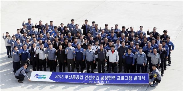 두산중공업이 지난해 3월 28일 경남 창원 공장 내 기술교육원에서 개최한 ‘안전보건 공생 협력단’ 발대식에서 78개 협력사 참석자들이 기념사진을 찍고 있다.  두산그룹 제공