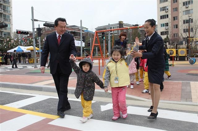 노현송(왼쪽) 강서구청장이 지역 어린이들의 안전한 하교를 위해 함께 횡단보도를 건너고 있다. 강서구 제공