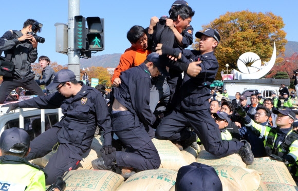 ‘쌀 전면 개방 저지, 한·중 자유무역협정(FTA) 중단, 농산물 가격폭락 대책’을 촉구하는 농민 시위대와 이를 막으려는 경찰이 10일 경남 창원시 경남도청 앞 트럭 위에서 함께 뒤엉키며 격렬한 몸싸움을 벌이고 있다. 창원 연합뉴스