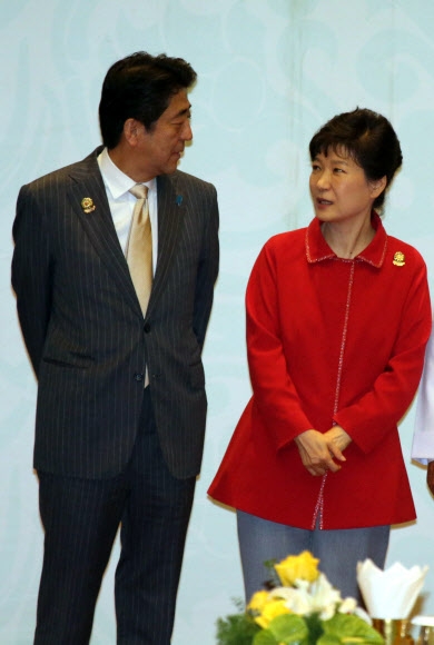 박근혜 대통령이 13일 오후 미얀마 국제회의센터(MICC)에서 열린 ‘아세안(ASEAN)+3 정상회의’ 기념촬영에서 아베 신조 일본 총리와 이야기를 나누고 있다.  연합뉴스