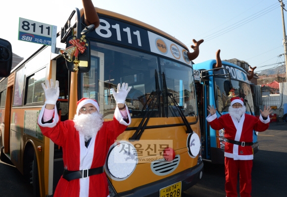 8일 오전 서울 강북구 수유동 동아운수 종점에서 눈동자가 움직이는 루돌프 타요버스 앞에서 산타복을 입은 운전기사들이 손을 흔들며 포즈를 취하고 있다. 서울시는 현재 운행 중인 타요버스 26대를 눈동자가 움직이는 루돌프 타요버스로 제작해 내년 1월 중순까지 한 달가량 운행할 계획이라고 밝혔다. 이 버스는 소외된 이웃들을 찾아가는 ’찾아가는 산타 타요(가칭)’ 행사도 진행한다. 13일엔 서대문구 구세군후생원과 강서구 지온보육원 2곳을, 20일엔 강동구 암사재활원과 노원구 다운복지관 2곳을 방문해 대중교통 안전교육과 타요공연, 산타마술쇼 등을 진행한다. 안주영 기자 jya@seoul.co.kr